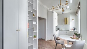 Een moderne keuken met witte kasten, een ronde eettafel en een visgraatvloer.