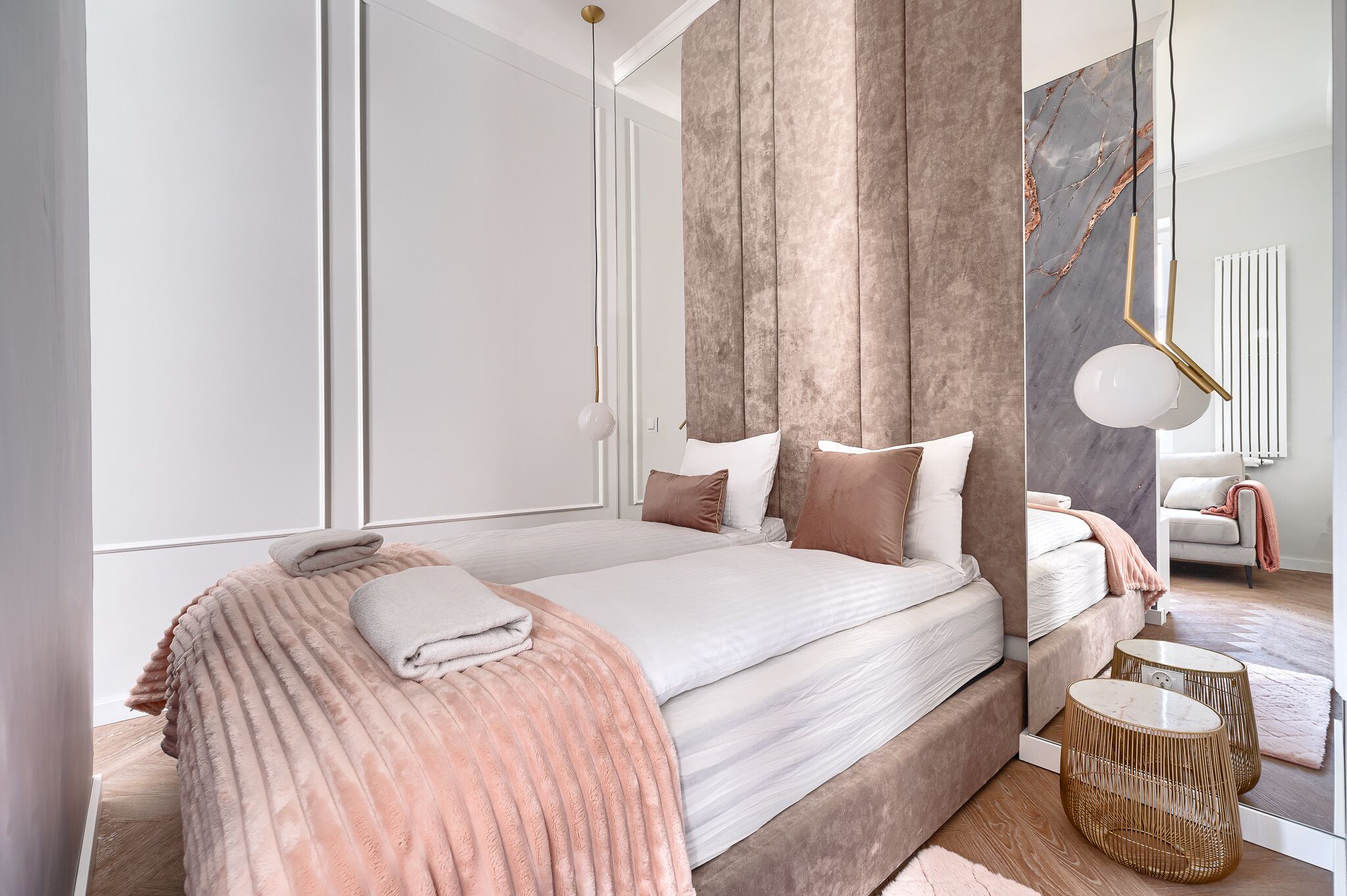 Un dormitorio moderno con una cama grande, un espejo y una mesita de noche.