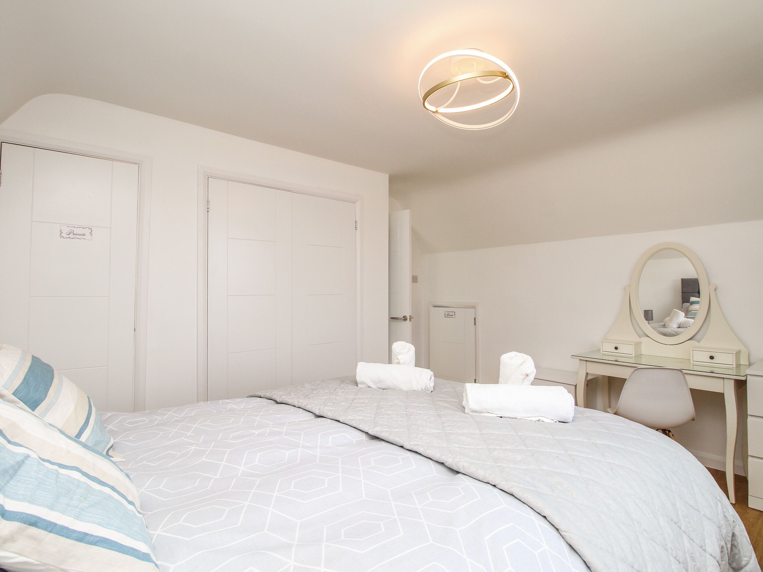 Un dormitorio con cama, cómoda, espejo y puerta.