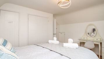Un dormitorio con cama, cómoda, espejo y puerta.
