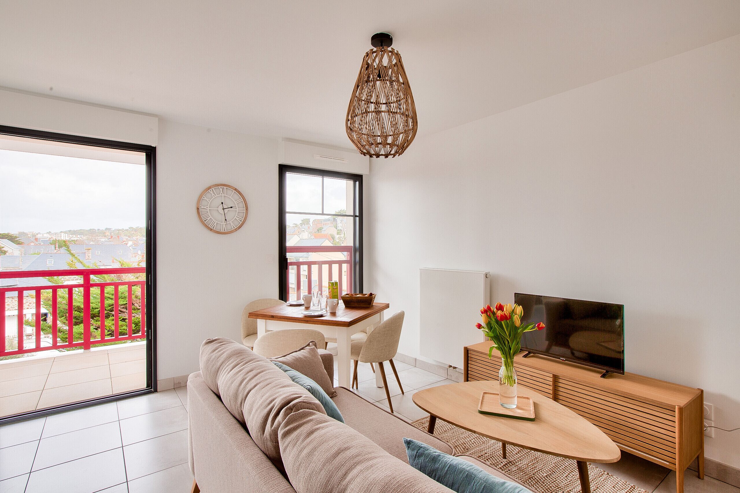 Un salon moderne avec un canapé, un téléviseur et un coin repas.