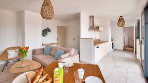 Un appartement moderne comprenant un coin repas, une kitchenette et un espace de vie.