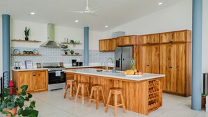 Una cocina moderna con una isla central, armarios de madera y taburetes de bar.