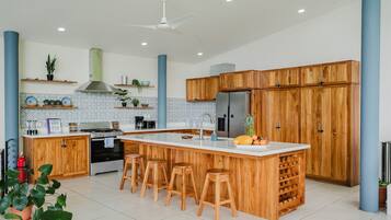 Una cocina moderna con una isla central, armarios de madera y taburetes de bar.