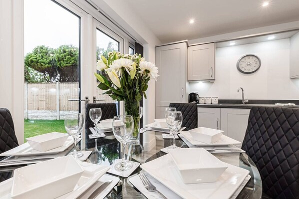 Enjoy meals in this stylish dining area with a glass table and comfortable seating.