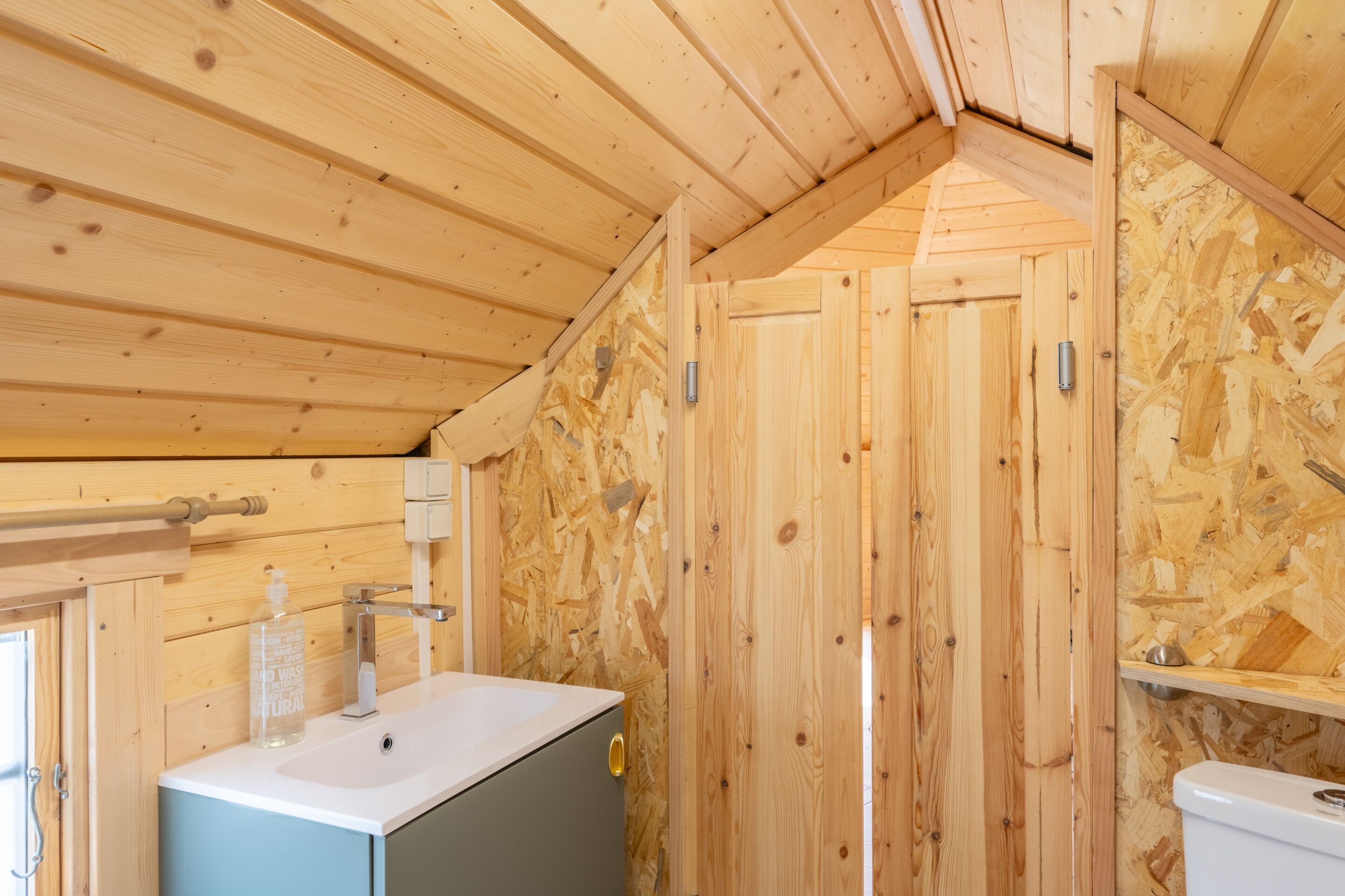 Un intérieur en bois comprenant un évier, un meuble et des toilettes.