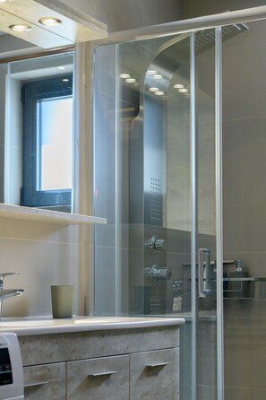 Deluxe-lejlighed | Badeværelse | Bruser, gratis toiletartikler, hårtørrer, håndklæder