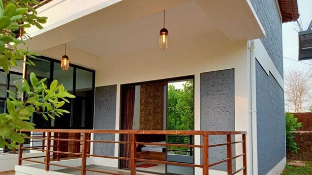 A modern house with a balcony, large windows, and a hanging light fixture. - D Star Entertainment Water ParkAndResort (Chiplun)