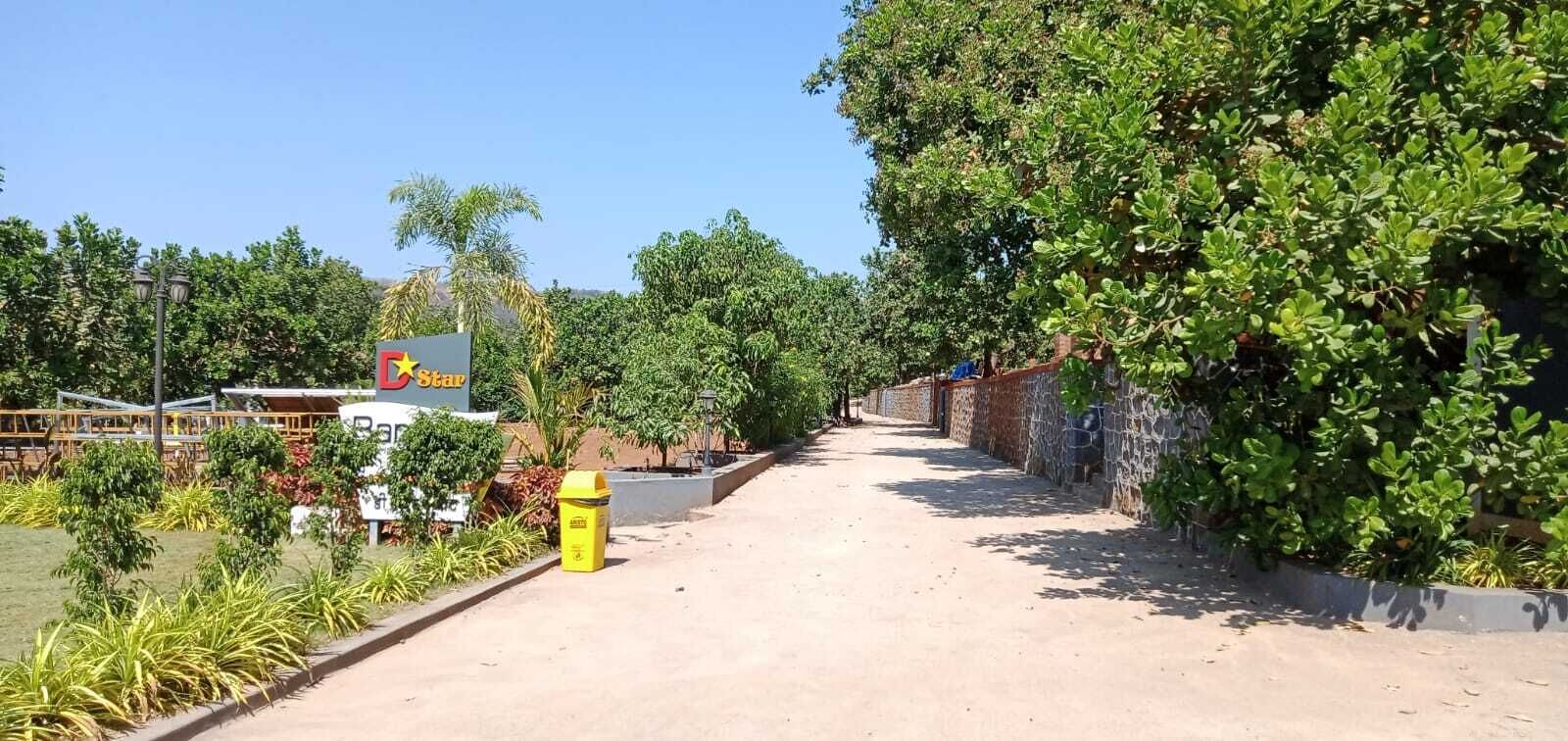 Un sendero conduce a un edificio con un letrero que dice 'Star', rodeado de follaje y un muro de piedra.
