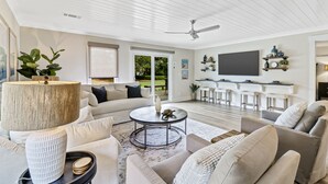 A modern living room with a sofa, coffee table, and a TV mounted on the wall. - Recently updated Palmetto Dunes villa with fairway views and community pools. (Hilton Head Island)