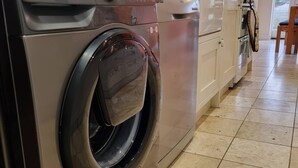A modern kitchen with a Samsung washing machine, a sink, and cabinets. - Charming Victorian Home - Discover the splendor of Oxford's City Spires (Oxford)