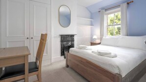 A bedroom with a bed, a desk, a chair, a fireplace, and a window. - Charming Victorian Home - Discover the splendor of Oxford's City Spires (Oxford)