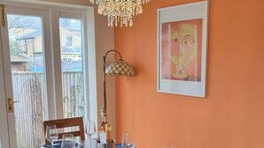 A dining area with a wooden table set for six, a chandelier, and a framed artwork on the wall. - Charming Victorian Home - Discover the splendor of Oxford's City Spires (Oxford)