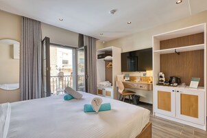 A hotel room with a bed, a desk, a wardrobe, and a balcony.