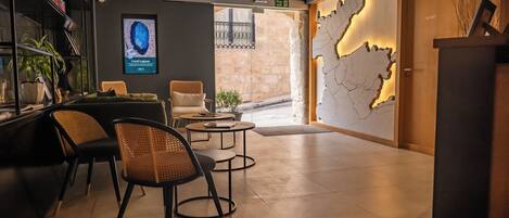 A modern interior with a reception desk, seating area, and a wall-mounted map.