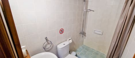 A bathroom with a shower, toilet, and sink.