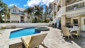 A pool area with lounge chairs, a hot tub, and outdoor furniture. - Massive Luxury Beach Home Private Pool Hilton Head (Hilton Head Island)