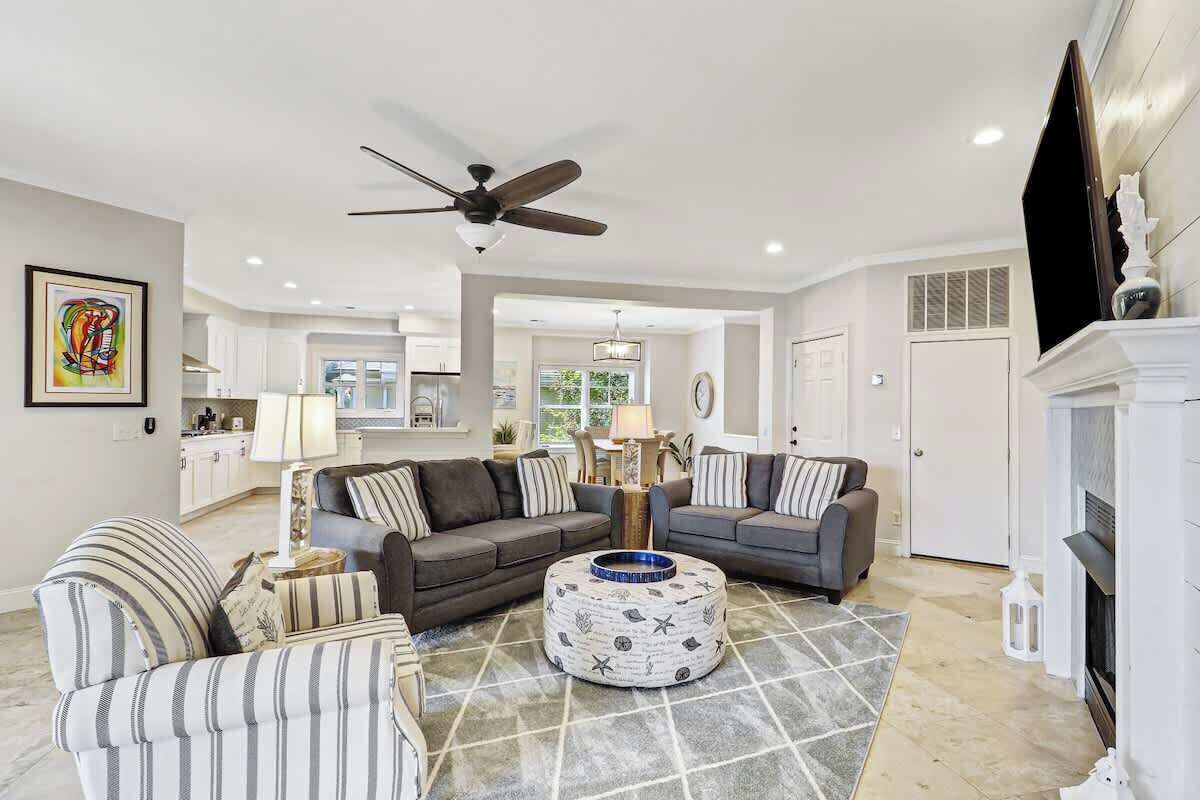 Unwind in your spacious living room featuring plush seating, modern fireplace, and open-concept design flowing seamlessly into the kitchen.