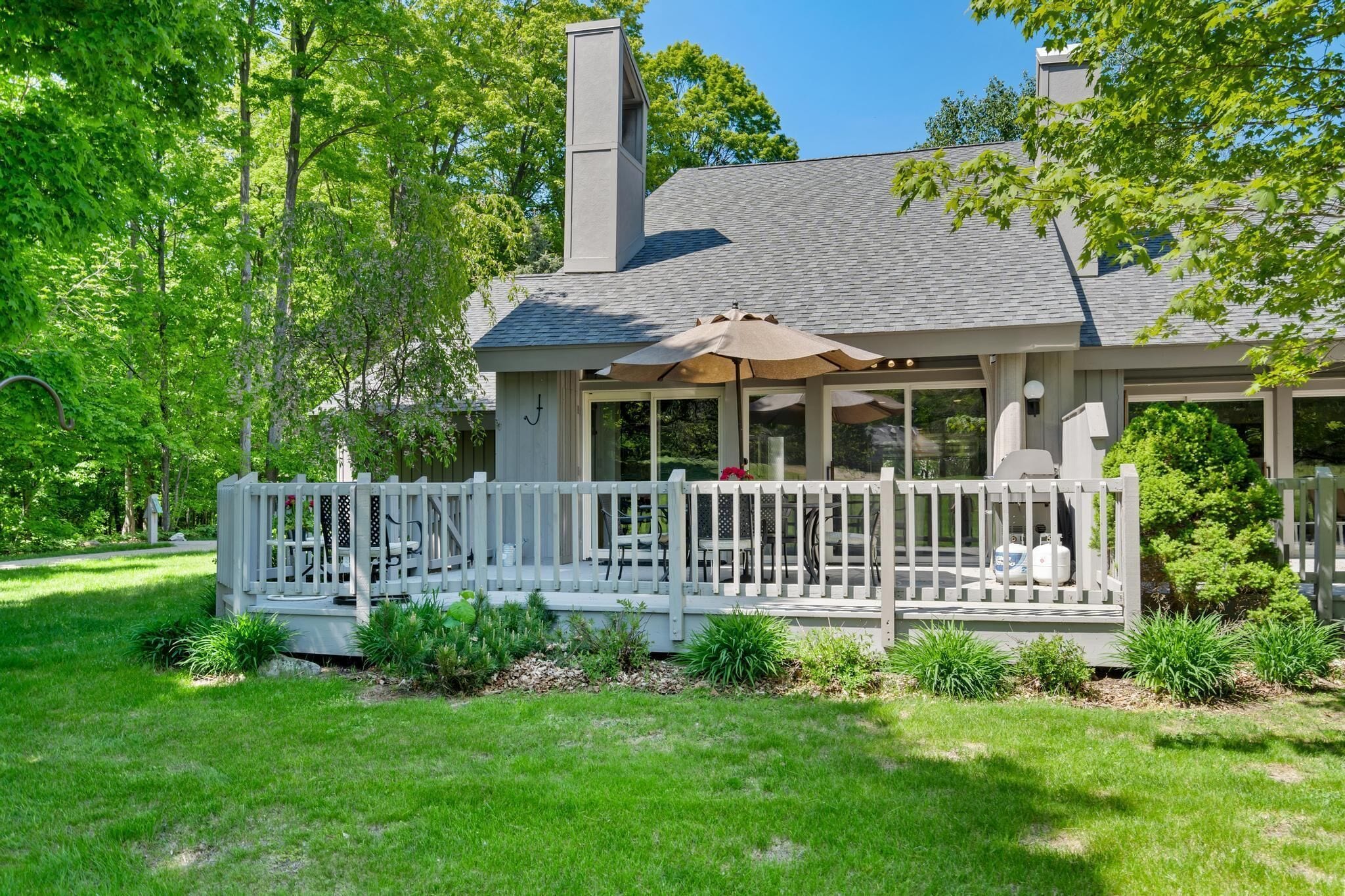 A house with a covered porch, a chimney, and a well-maintained garden.