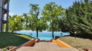 A pathway leading to a body of water with trees and a building on one side. - July Morning Seaside Resort (Kavarna)