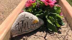 A pathway leading to a beach with a welcome sign on a rock. - July Morning Seaside Resort (Kavarna)