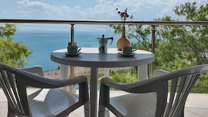 A round table with two chairs on a balcony overlooking a beach. - July Morning Seaside Resort (Kavarna)