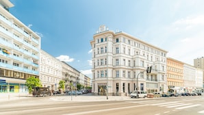 A multi-story building with a classic architectural style, featuring a prominent clock tower and a corner entrance. - MARGI Maya Apartments (Szczecin)