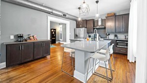 A modern kitchen with a central island, bar stools, dark cabinets, and stainless steel appliances. - 8 min to Stadiums & Dwntn Cincy, 1BR in Ludlow KY (Ludlow)
