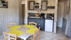 A compact kitchen with wooden cabinets, a microwave, and a coffee maker. - Gîte l'Oule near Thiers - 4 people in Viscomtat (Viscomtat)