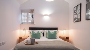 A bedroom with a large bed, two bedside tables, a window with blinds, a wall-mounted light fixture, and a framed picture. - Contemporary Home Nr Kirkby Lonsdale - Spacious Garden (Carnforth)