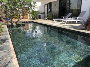 A clear swimming pool with lounge chairs and a modern house in the background. - Villalina: cosy, private pool and close to Grand Bay and beaches (Pereybere)