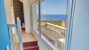 Eine Treppe führt zu einem Balkon mit Blick auf das Meer.