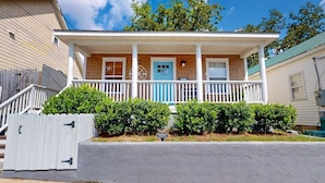 A two-story house with a porch, a mailbox, and a property surveillance sign. - Mins to Downtown, Live Oak Concerts, Convention Center & Beach! Pet Friendly!! (Wilmington)