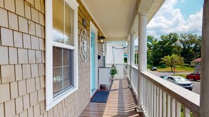 Enjoy the serene atmosphere on this inviting porch, complete with a metal railing and windows.