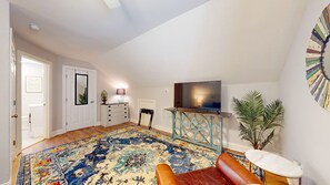 Relax in this inviting living room with a comfortable sofa, flat-screen TV, and potted plant.