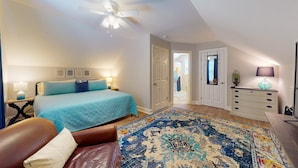 A bedroom with a bed, a ceiling fan, a nightstand, a dresser, and a door leading to another room. - Mins to Downtown, Live Oak Concerts, Convention Center & Beach! Pet Friendly!! (Wilmington)
