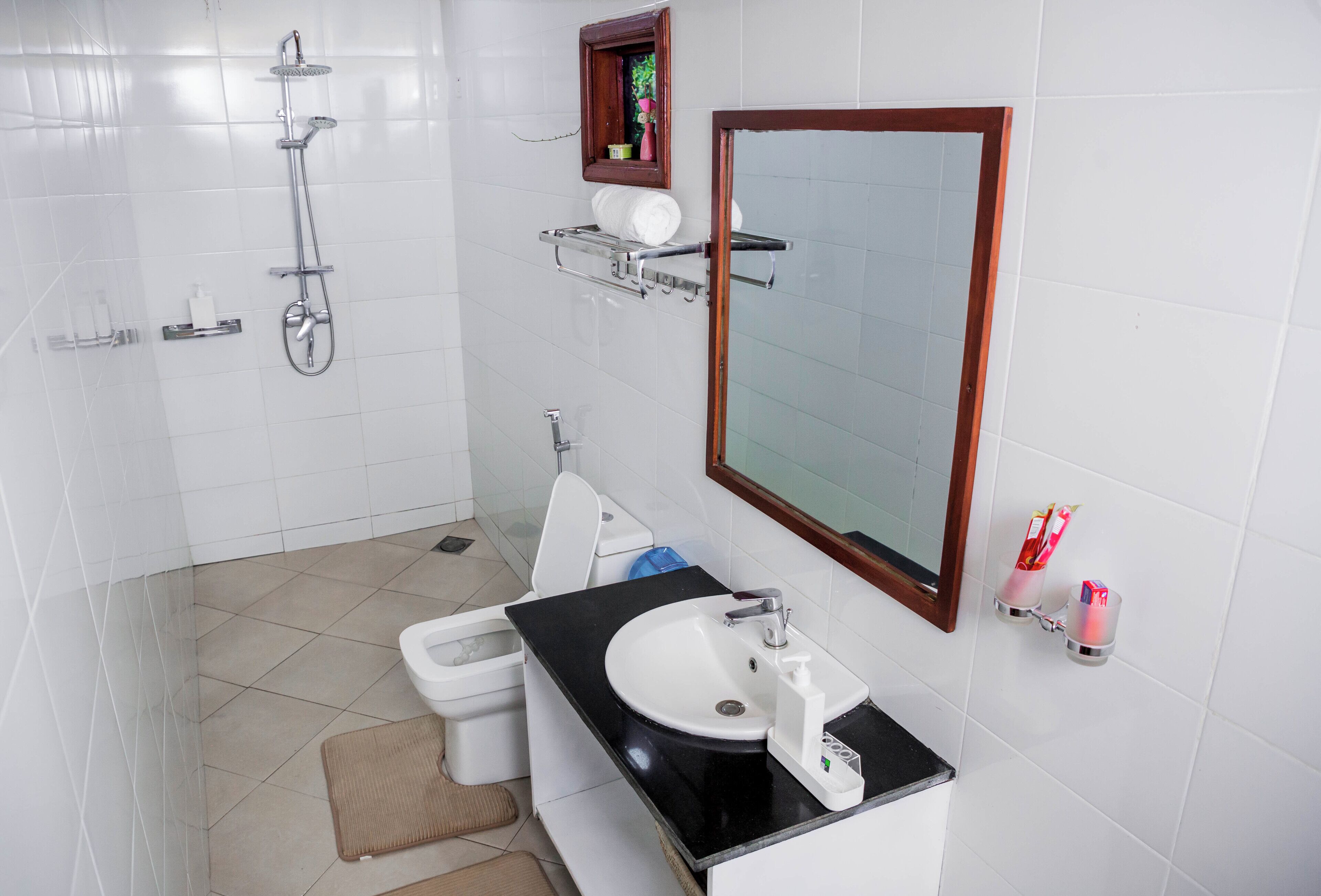 Un baño moderno con ducha, inodoro, lavamanos y espejo.
