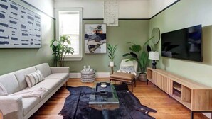 Un salon moderne avec un canapé, une table basse et un téléviseur fixé au mur.