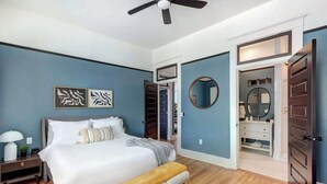 A bedroom with a bed, bedside table, and a ceiling fan. - Tidewater Blue @ The Huntingdon Lofts Collection (Savannah)
