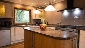 Cocina moderna con encimera de granito, electrodomésticos de acero inoxidable y una isla central con frutero.