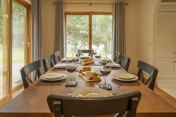 A dining table set for a meal with plates, glasses, and a cheese board.