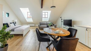 Een modern loft appartement met een groot bed, een eethoek en een televisie.