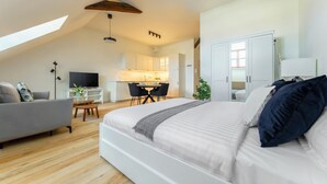 Een moderne loft slaapkamer met een groot bed, een bureau en een kitchenette.