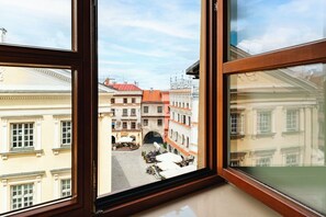 A view from a window of a building with a street scene, including buildings and a bridge.