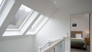 A bedroom with a bed, a nightstand, and a painting on the wall. - Sleeps 6 in 2 doubles and 1 twin room (Dulnain Bridge)