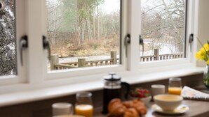 Ein Frühstückstisch mit Kaffeekanne, Croissants und einer Schüssel Müsli.