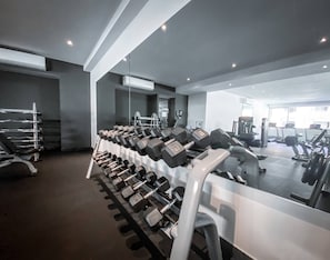 A gym with exercise equipment, including dumbbells and treadmills.