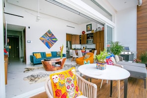 A modern living space with a sofa, coffee table, and a dining area with chairs. - Luxe Penthouse w/Premium Amenities @ Romantic Zone (Puerto Vallarta)