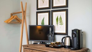 A wooden dresser with a television, a coffee maker, and a tray with cups. - The Bottle & Glass Inn – Garden View Room 1 (Henley-on-Thames)