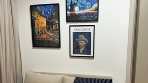 A living room with a beige sofa, two pillows, and three framed artworks on the wall. - Flat Itaim SP (São Paulo)